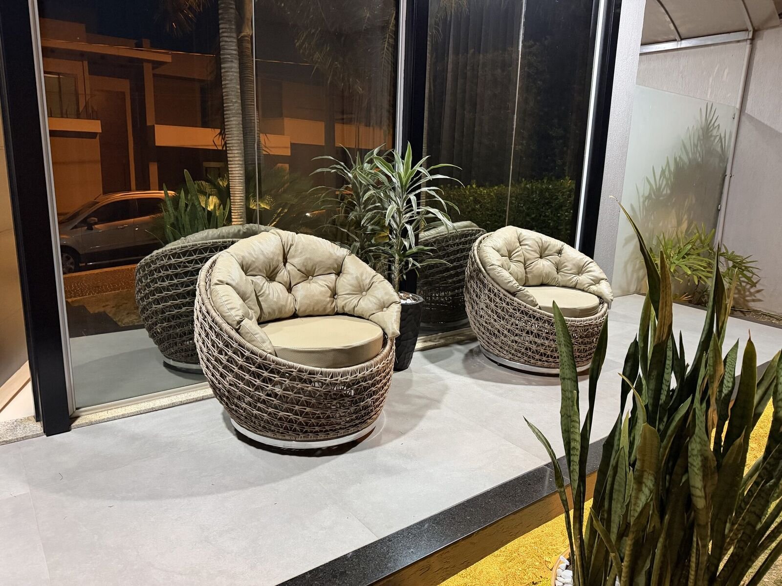 Poltronas trançadas junto a fachada envidraçada
