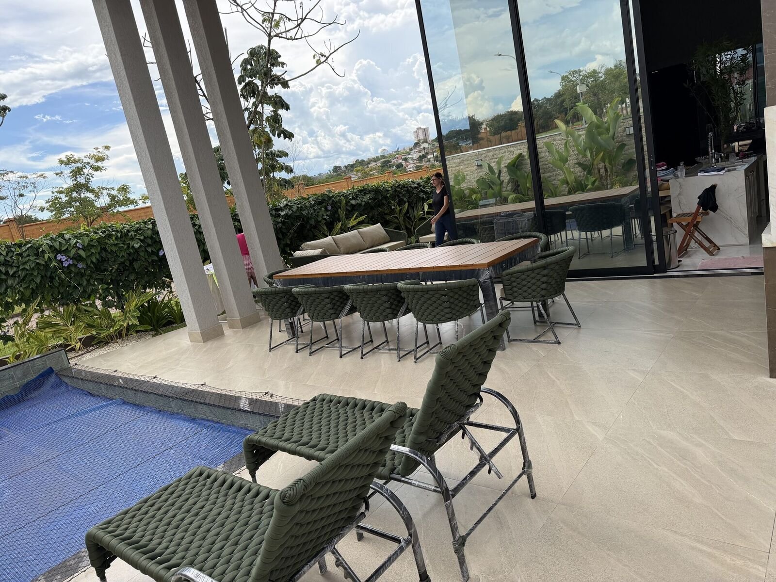 Área gourmet integrada com vidro e mesa de jantar